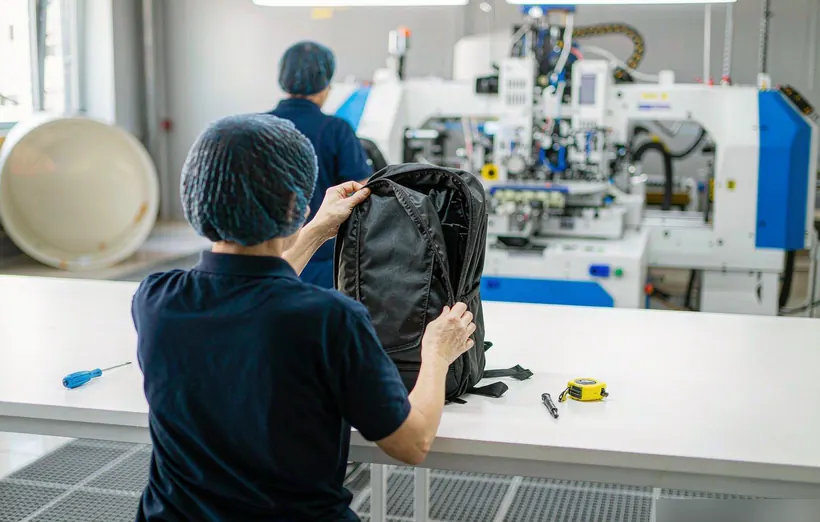 Quality inspector checking backpack in Kovoeky factory